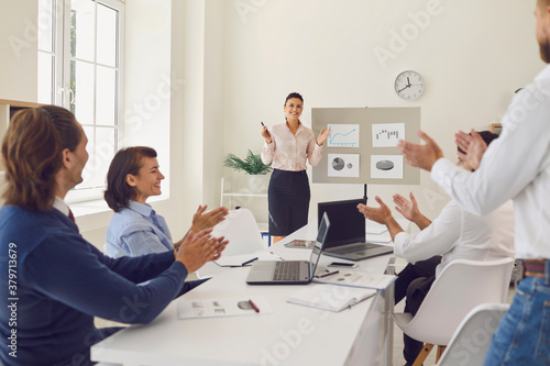 Fotografía Happy employees celebrating sales increase in corporate meeting with sales manag