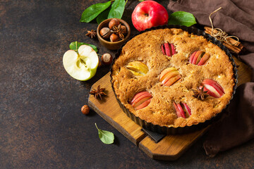 Wall Mural - Apple baking seasonal. Apple pie with hazelnut and cinnamon on a rustic wooden table. Free space for your text.
