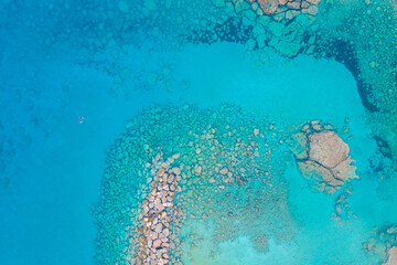 Wall Mural - An aerial view of the beautiful Mediterranean Sea, where you can see the cracked rocky textured underwater corals and the clean turquoise water of Protaras, Cyprus,