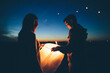 © Brian Powell/Stocksy - young couple lighting Chinese lanterns at twilight