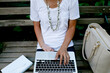 © Jennifer Brister/Stocksy - woman typing on keyboard on park bench