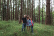 © Rob and Julia Campbell/Stocksy - Happy family of three looking at camera together outside in nature