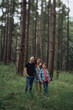 © Rob and Julia Campbell/Stocksy - Happy family of three looking at camera together outside in nature