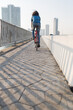 © Jovo Jovanovic/Stocksy - Rear view of a man riding a bicycle on the bridge