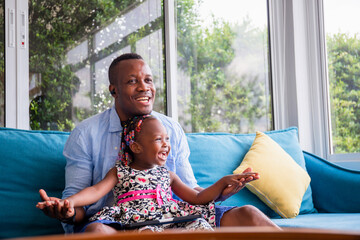 Wall Mural - African american father and daughter playing in living room, Happiness family concepts