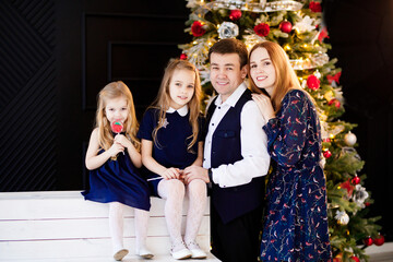 Wall Mural - father, mother and daughters in new year decor. family photo shoot for Christmas. annual traditions of celebration. happy and fun holidays.