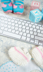 Wall Mural - Baby nursery clothing mom bloggers desktop workspace with pink and blue accessories and shopping cart on white marble textured background. Top view blog hero header creative composition flat lay.