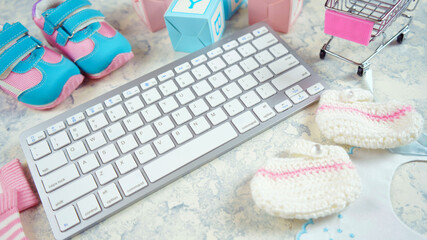 Wall Mural - Baby nursery clothing mom bloggers desktop workspace with pink and blue accessories and shopping cart on white marble textured background. Top view blog hero header creative composition flat lay.