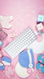 Fototapeta Kwiaty - Baby nursery clothing mom bloggers desktop workspace with pink and blue accessories on stylish pink textured background. Top view blog hero header creative composition flat lay. Negative copy space.