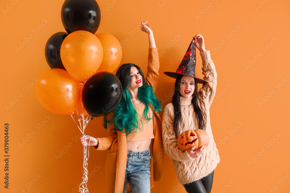 Beautiful young women with Halloween decor on color background