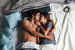 © Viktor Solomin/Stocksy - Young sensual couple lying in bed together