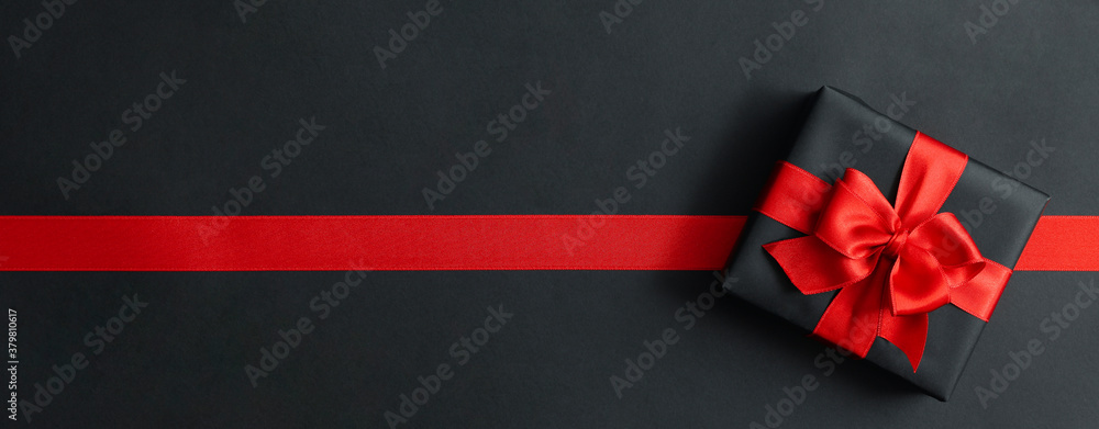 Gift box and red ribbon on black background - obrazy, fototapety, plakaty 