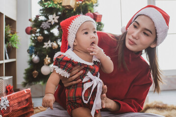 merry christmas and happy Holidays. mother held her daughter near the christmas tree and decorate the christmas tree indoors. the morning before Xmas. Portrait loving family close up.