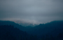 Moody And Dark Scene With Layers Of Mountains And Trees