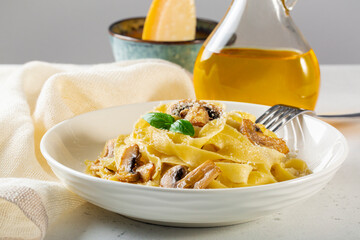 Canvas Print - Homemade egg pasta tagliatelle with mushrooms and cheese, olive oil with truffle, extra-hard cheese on background.