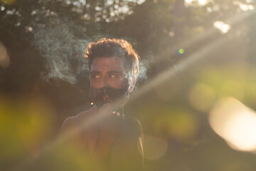 Hombre con mascarilla y humo en la naturaleza