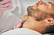 Good-looking young man undergoing laser hair removal procedure