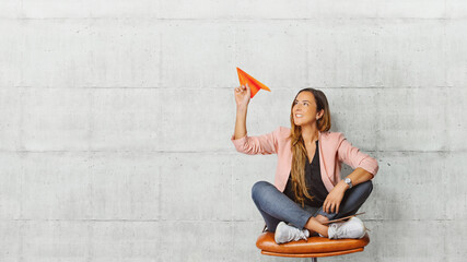  Young beautiful woman holding hand model paper air plane. Design of travel concept with air plane on empty gray color background