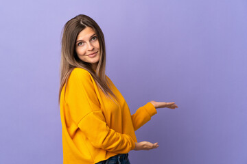 Young Slovak woman isolated on purple background extending hands to the side for inviting to come