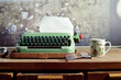 © Marija Anicic/Stocksy - Vintage retro typewriter and cup of coffee with cookie on wooden desk