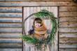 © Adrian Cotiga/Stocksy - Young woman holding a big fir wreath made for Christmas