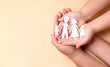 man and women hands holding paper family  in studio With copy space, homeschooling education, domestic violence,family home, foster care, homeless support, social distancing, world mental health day.