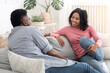 © Prostock-studio - Communnication In Relationships. Loving Black Couple Chatting Together On Couch At Home