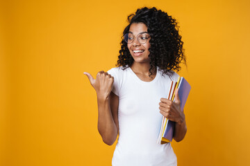 Wall Mural - Image of woman pointing finger aside and holding exercise books