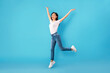 © Prostock-studio - Happy woman jumping over blue studio wall