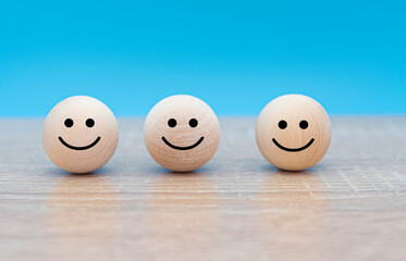 Three happy faces, wooden circle faces with smiles, concept picture