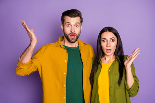 Photo pretty lady handsome guy couple raise hands watch tv news not believe eyes bad disease infection spreading wear casual shirts clothes isolated purple color background