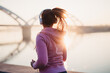 © hedgehog94 - Beautiful young and fit woman in good shape running and jogging alone on city bridge street. She wearing protective face mask to protect herself from virus or allergy infection. Sunset in background.