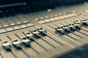 Professional audio mixing console with faders and adjusting knobs, TV equipment Black and White selective focus