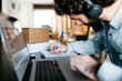 © Guille Faingold/Stocksy - Busy man writing down in planner at laptop.
