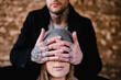 © Thais Varela/Stocksy - tattoed man covering the eyes of a woman