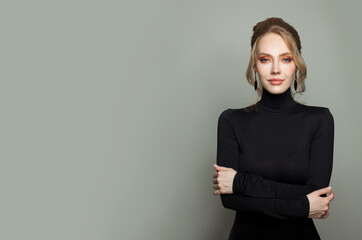 Wall Mural - Pretty young woman with crossed arms on gray background