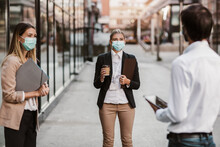 Three Employers Standing In Social Distance Wearing Face Mask Looking At Each Other And Talking