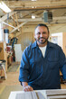 © Jetta Productions/Stocksy - Portrait of a smiling hispanic blue collar worker