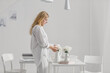 © Lumina/Stocksy - Woman Arranging Flowers and Decor