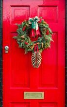 Red Front Door To UK House With Christmas Wreath