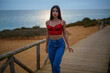 © Tony Moguer - Chica caminando por ruta de playa camino de madera y vegetacion junto a un acantilado en cadiz el sur de españa