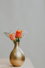 Two Fresh Orange Roses In A Metallic Vase