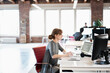 © Jetta Productions/Stocksy - Young female office worker sits at computer looking at monitor i