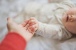 © Lauren Naefe/Stocksy - Baby grasping mom's hand