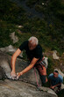 © Dimitrije Tanaskovic/Stocksy - Middle age man free climber climbing in nature