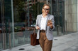 © Kostiantyn - Checking important email. Portrait of a confident attractive business woman in classic wear using smartphone on the way to office
