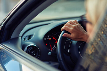 Close up rear view of a woman driving car through the city