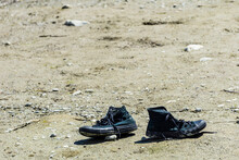 Pair Of Old Black Dirty Boots Forgotten In Empty Field