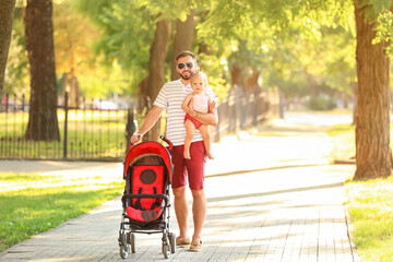 Man and his cute baby in stroller outdoors