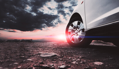 Wall Mural - car travel and adventur. closed image of car wheels and tires on the ground and sunset sky